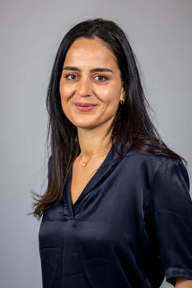 Portrait d'une femme d'affaires souriante sur fond gris