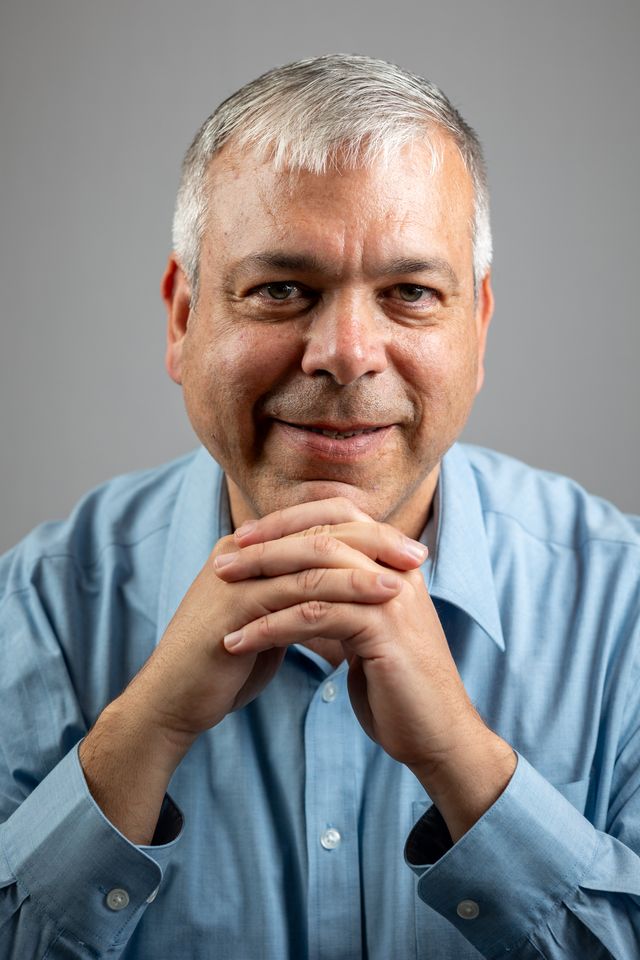 Portrait d'un homme souriant, mains jointes
