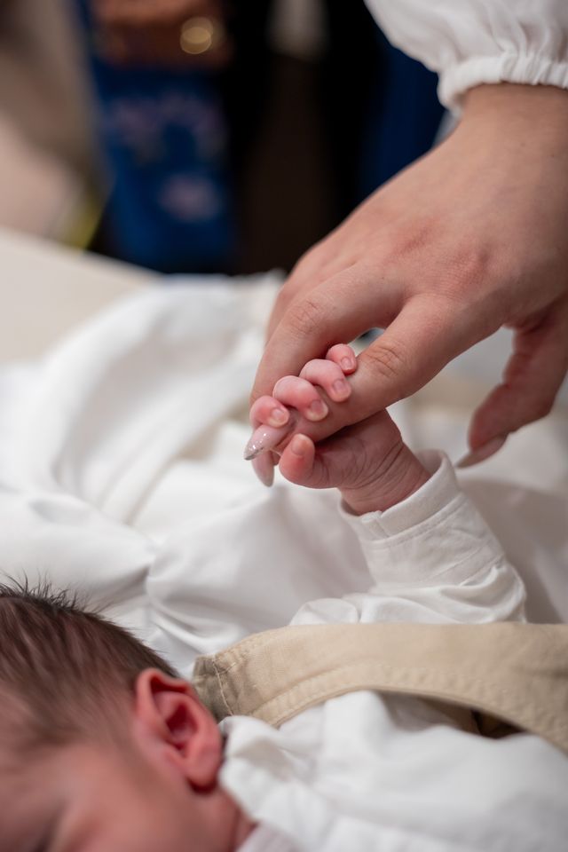 La petite main d'un nouveau-né serre le doigt d'un adulte
