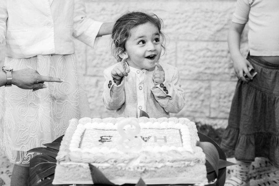 Une petite fille rit devant son gâteau de chalaké